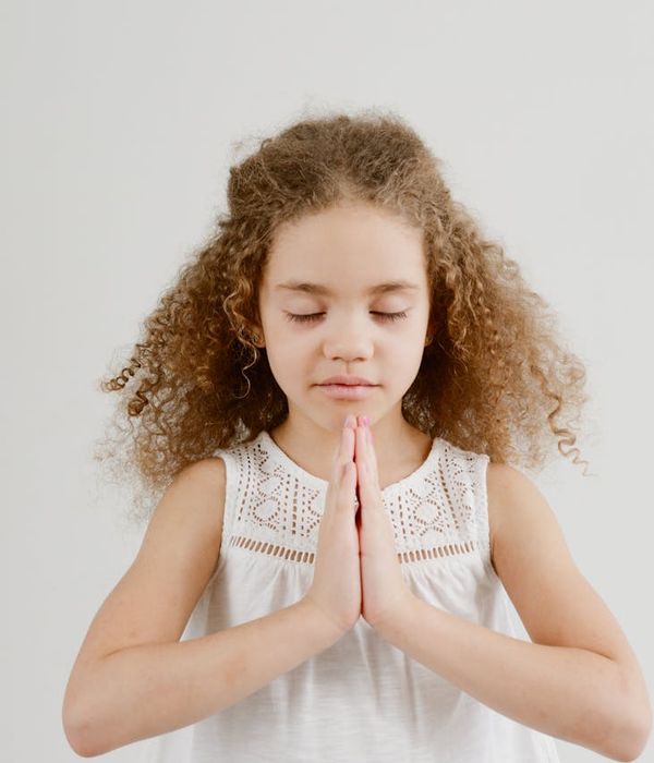Young child in a peaceful tree yoga pose, bright and focused.
